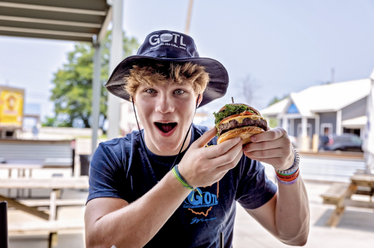Teen boy holding burger.