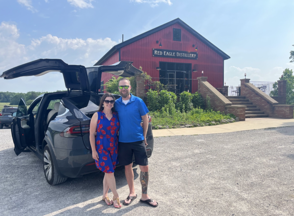 Couple in front of luxury rental car.