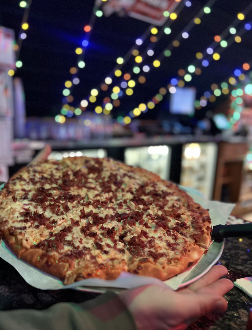 Pizza in restaurant with Christmas lights.